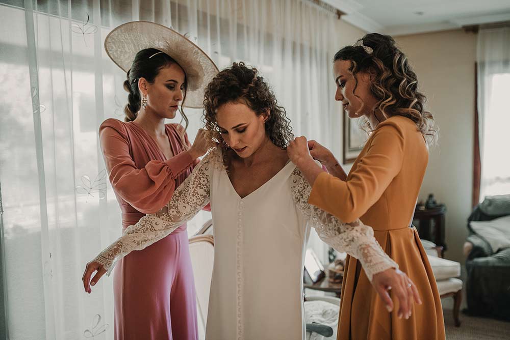 Fotógrafo de boda // dos amigas ayudando a la novia