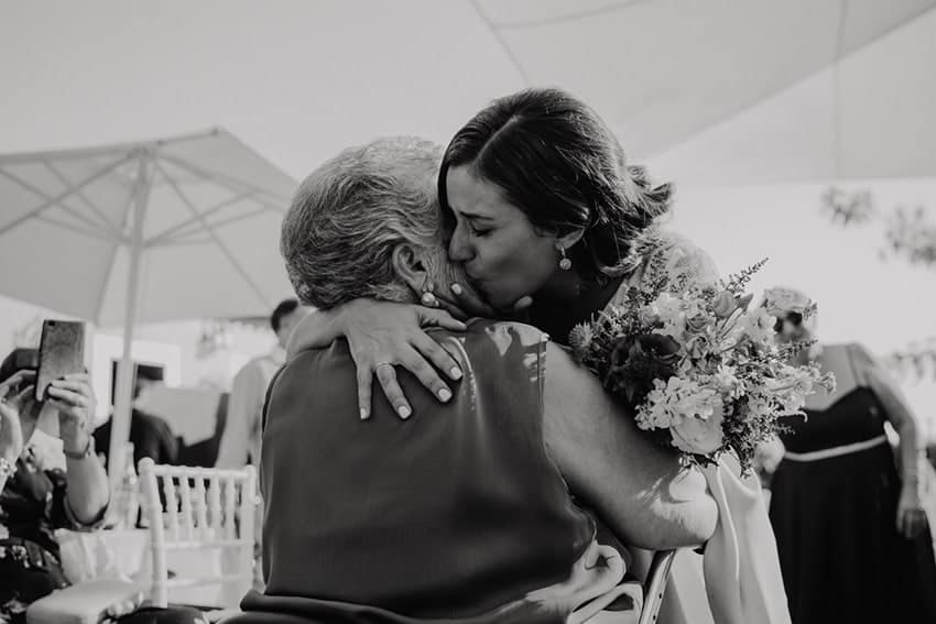 Novia besando emocionada a invitada mayor, abuela