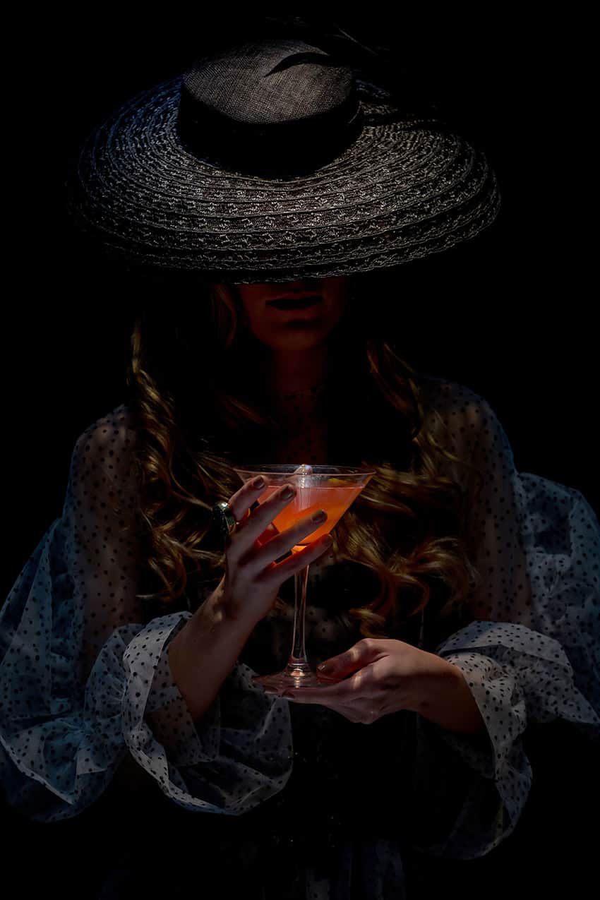 Mujer con tocado y cocktail