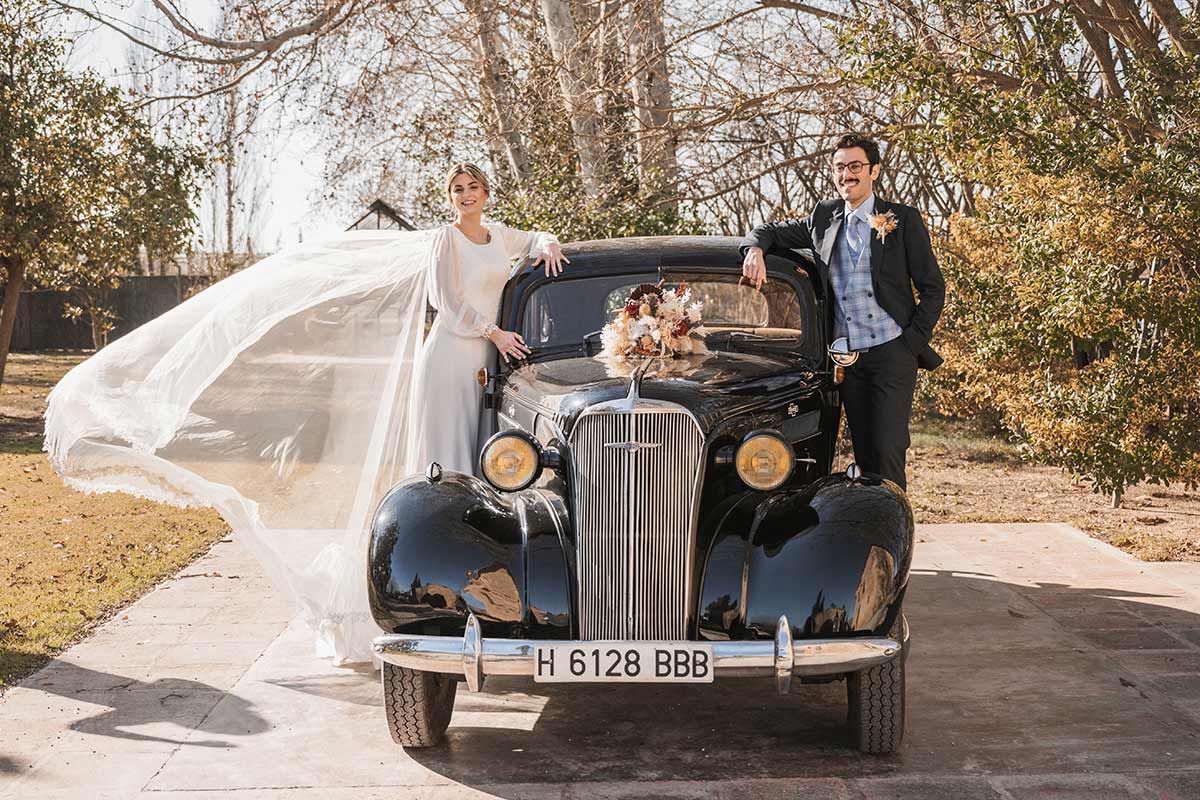 Novios con coche clásico de bodas