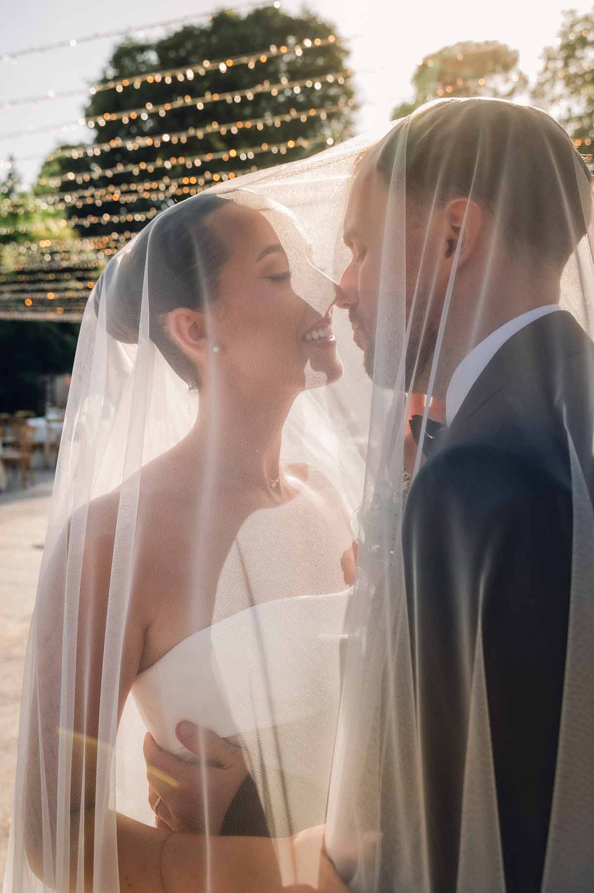 Novios besándose bajo el velo de novia