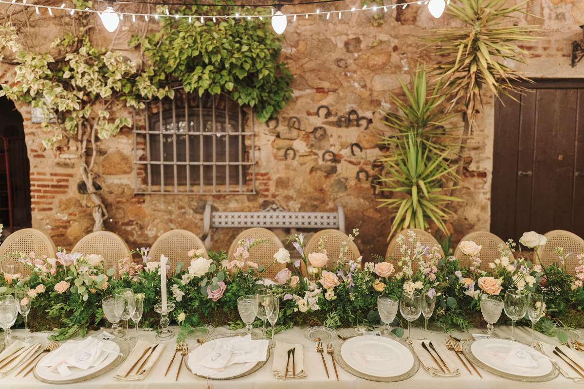 decoración de mesas de boda con caminos de follaje verde y flores
