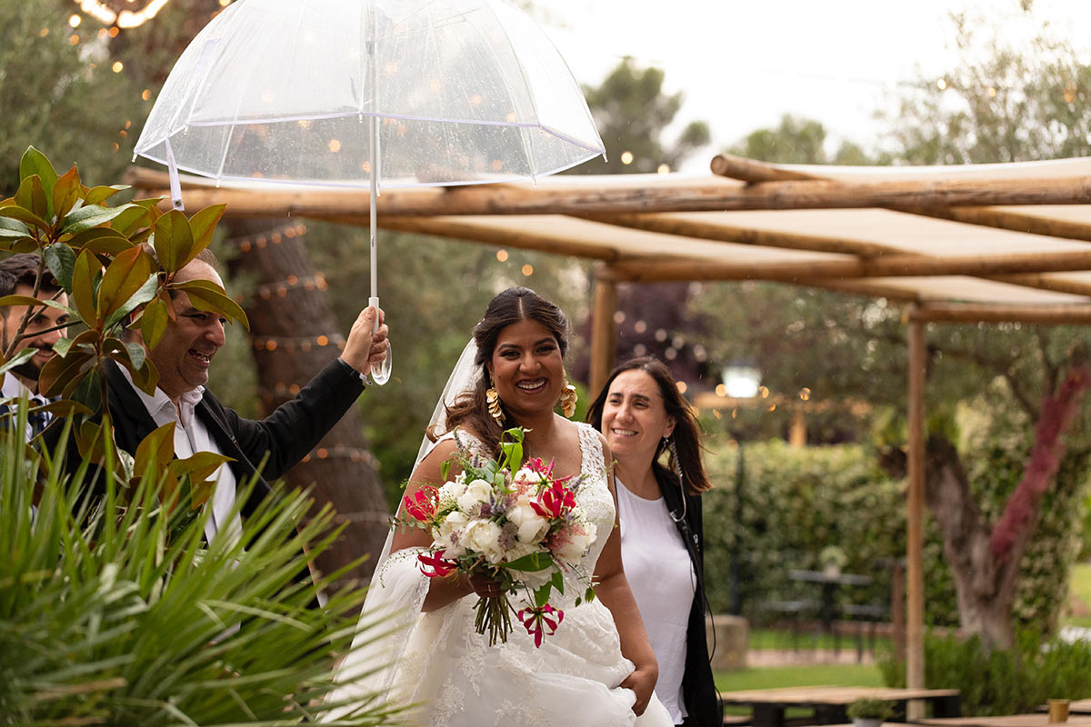 Wedding planners acompañando a una novia con paraguas