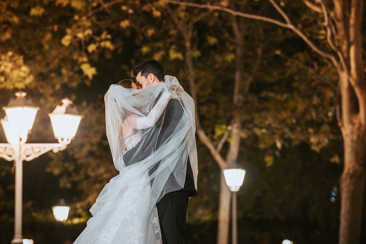Novios en los jardines de Villa Laureana velo de novia