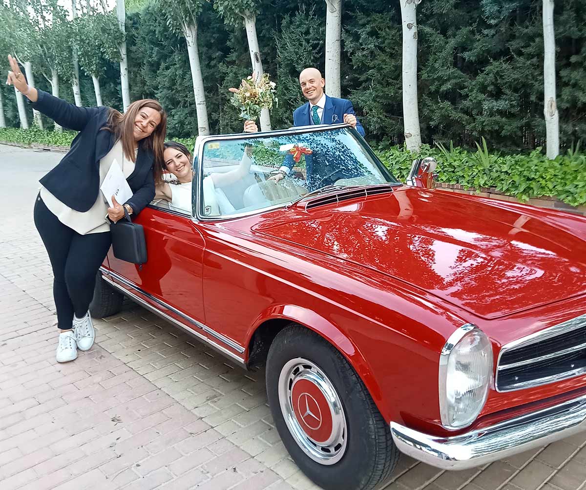 Novios en coche clásico rojo con el equipo de Grandes Momentos Weddings
